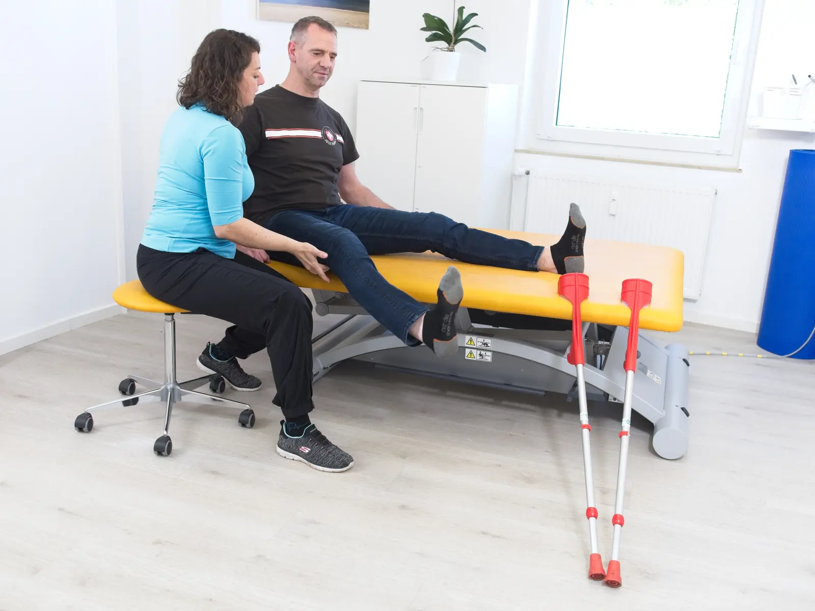 Patient steht von der Behandlungsliege auf